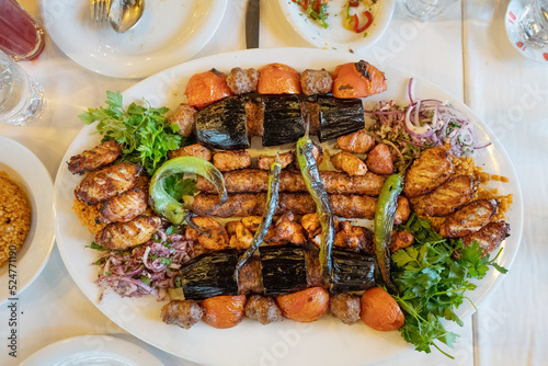 Photography close up of kebab meat platter on plate with chilli and onion