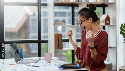 Cheerful and beautiful Asian businesswoman is excited and delighted that she has successfully accomplished her goals beautifully.