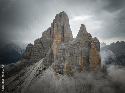 Cloudy day after the storm in the Dolomites mountains with mountain peaks looking up from the fog  mist  and clouds. 