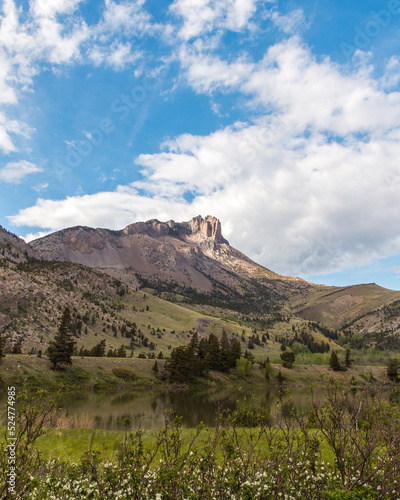 Valley with lake near striking rocky mountain peaks. Cloudy sky on a summer day in the American Rockies.