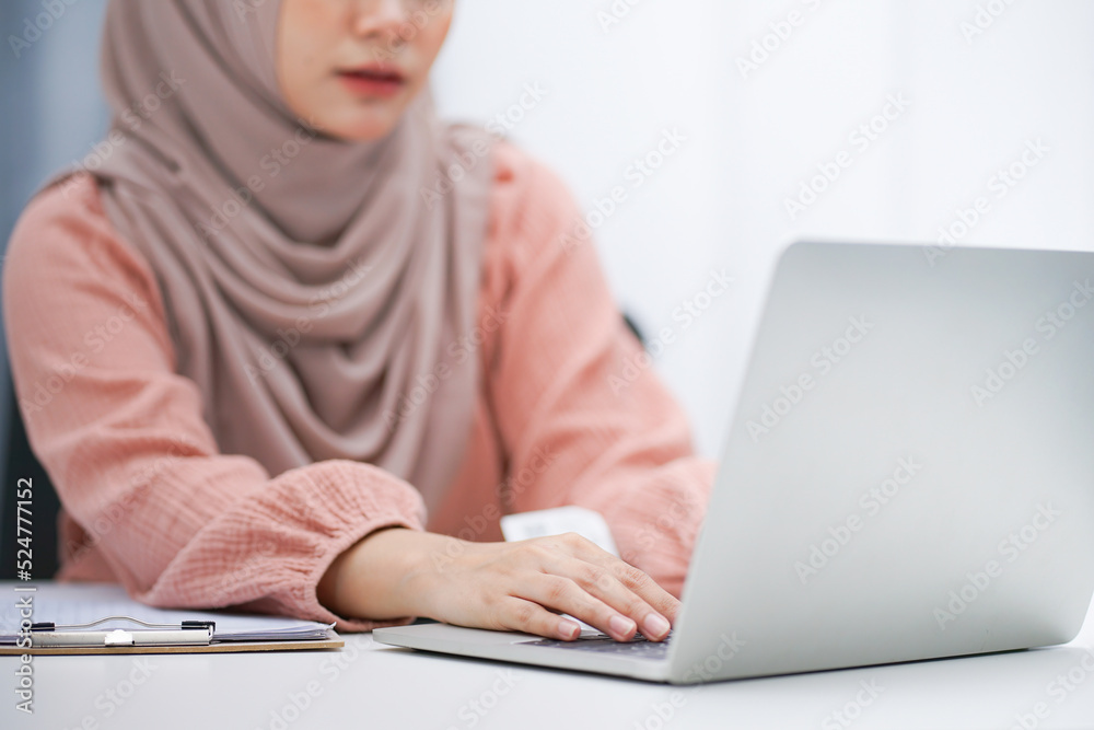 Cropped shot of asian muslim woman brown hijab working at her home. Cropped shot of asian muslim woman brown hijab working at her home.