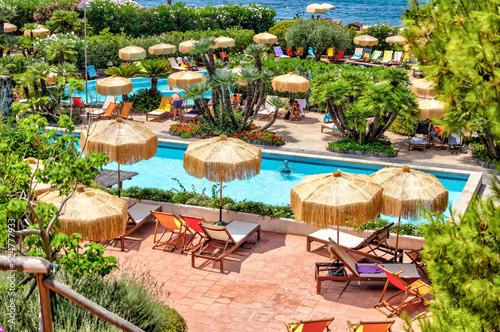 Fototapeta Naklejka Na Ścianę i Meble -  Rustic stairs and pathways amongst the colourful beach chairs and umbrellas in the hot springs on the island of Ischia in Italy
