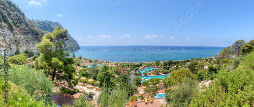 Fototapeta Naklejka Na Ścianę i Meble -  Rustic stairs and pathways amongst the colourful beach chairs and umbrellas in the hot springs on the island of Ischia in Italy
