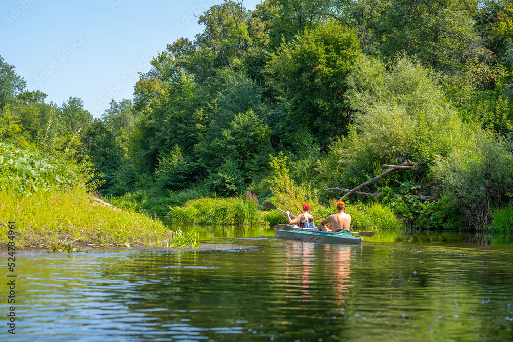 A man and a woman rowing oars in a kayak. Rafting on the fast river. Adventure traveling lifestyle. Concept wanderlust. Active weekend vacations wild nature outdoor.