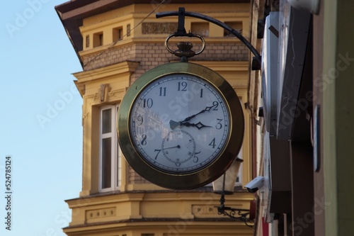 clock hanging above the street on the wall of a building in Inowrocław, Poland