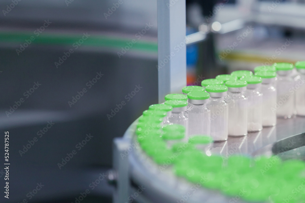 Vaccine Serum Bottles transfer on Conveyor Belt System. Industrial, Business and technology concept for food, health and medical factory. Industrial Medical Machine in factory. Vaccine Serum Bottles transfer on Conveyor Belt System. Industrial, Business and technology concept for food, health and medical factory. Industrial Medical Machine in factory.