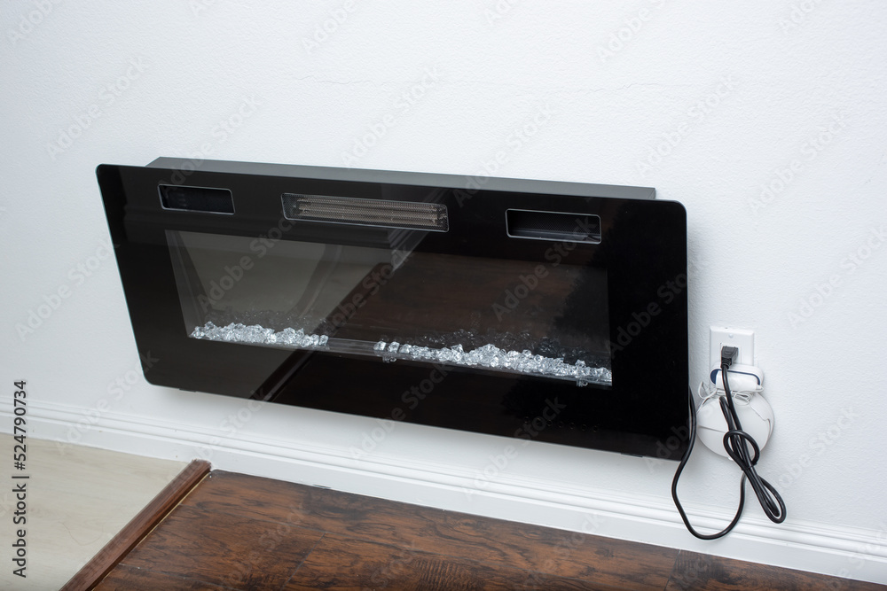 A view of an electric fireplace wall mount insert, seen inside a bedroom. A view of an electric fireplace wall mount insert, seen inside a bedroom.