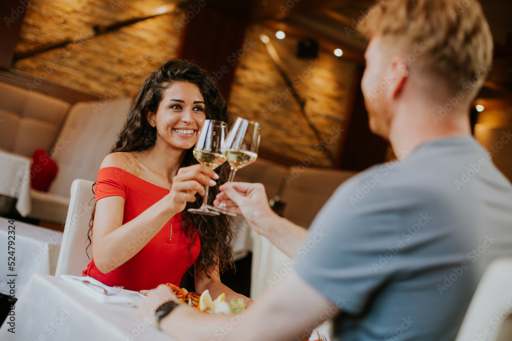 Young couple having lunch with white wine in the restaurant Young couple having lunch with white wine in the restaurant