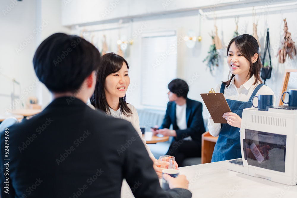 カフェで注文を取る若いスタッフ カフェで注文を取る若いスタッフ