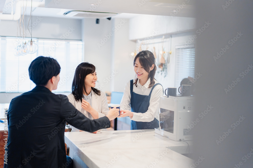 Obraz premium カフェで注文を取る若いスタッフ