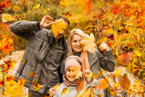 family  childhood  season and people concept - happy family playing with autumn leaves in park