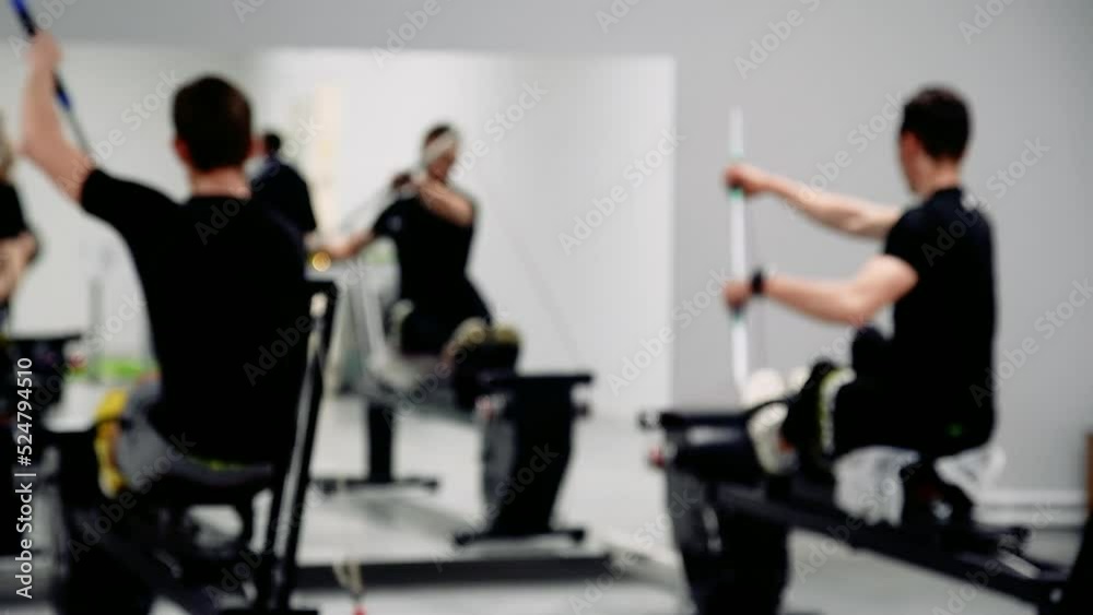 Men train in the gym on the ergometer simulator for kayaking