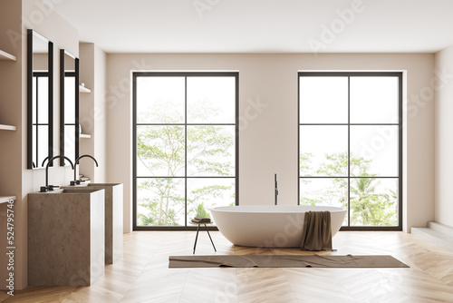 Light bathroom interior with sink and tub, panoramic window
