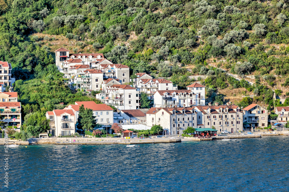 Kotor, Montenegro - July 18, 2022: Shoreline buildings and piers outside of Kotor, Montenegro
