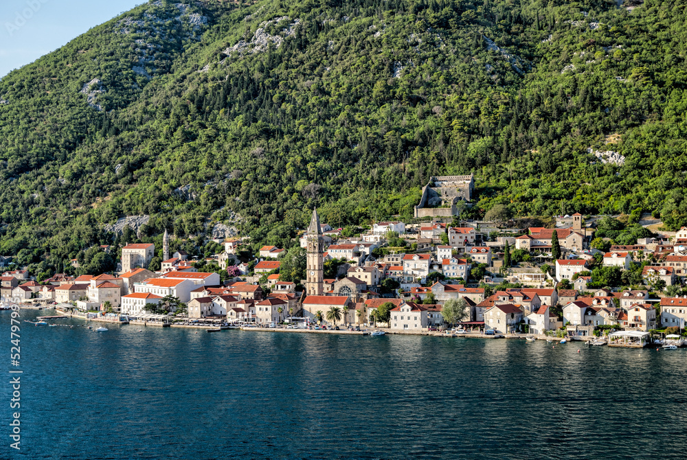 Kotor, Montenegro - July 18, 2022: Shoreline buildings and cathedrals along the narrow fjord en route to Kotor, Montenegro
