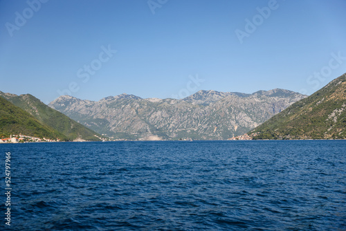 Kotor, Montenegro - July 18, 2022: Shoreline buildings and cathedrals along the narrow fjord en route to Kotor, Montenegro 