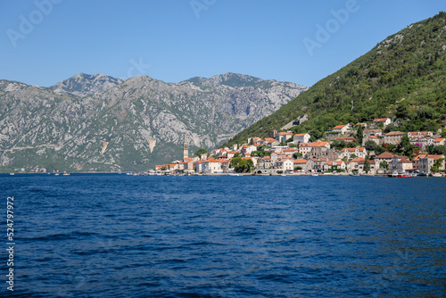 Kotor, Montenegro - July 18, 2022: Shoreline buildings and cathedrals along the narrow fjord en route to Kotor, Montenegro 