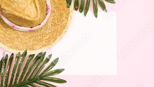 Summer beach background with straw hat palm leaves pastel pink background with copy space. Flat lay