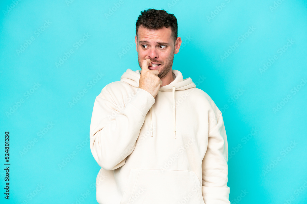 Young caucasian handsome man isolated on blue background nervous and scared Young caucasian handsome man isolated on blue background nervous and scared