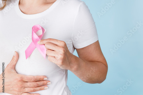 Tela Breast cancer awareness ribbon. Woman holding pink ribbon.