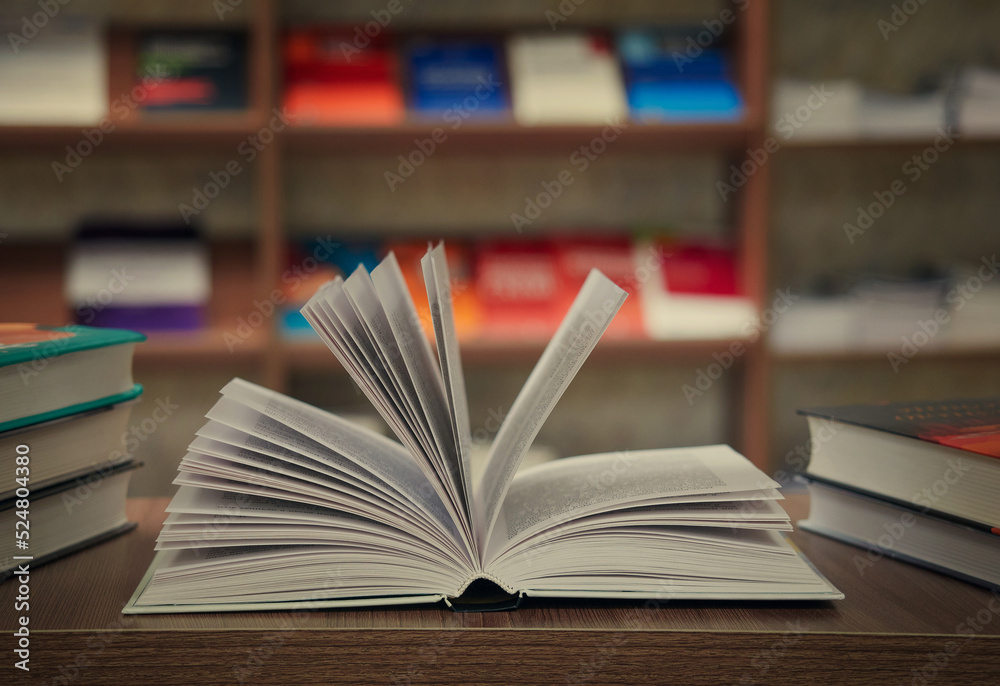 The concept of teaching education with the opening of a book or textbook in an old library, a stack of piles of literary text, an academic archive on the reading table and the passage of bookshelves i The concept of teaching education with the opening of a book or textbook in an old library, a stack of piles of literary text, an academic archive on the reading table and the passage of bookshelves i