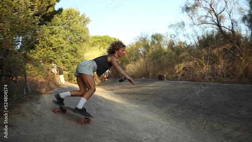Pair of young adult skaters skating in a water channel at sunset on a summer evening.