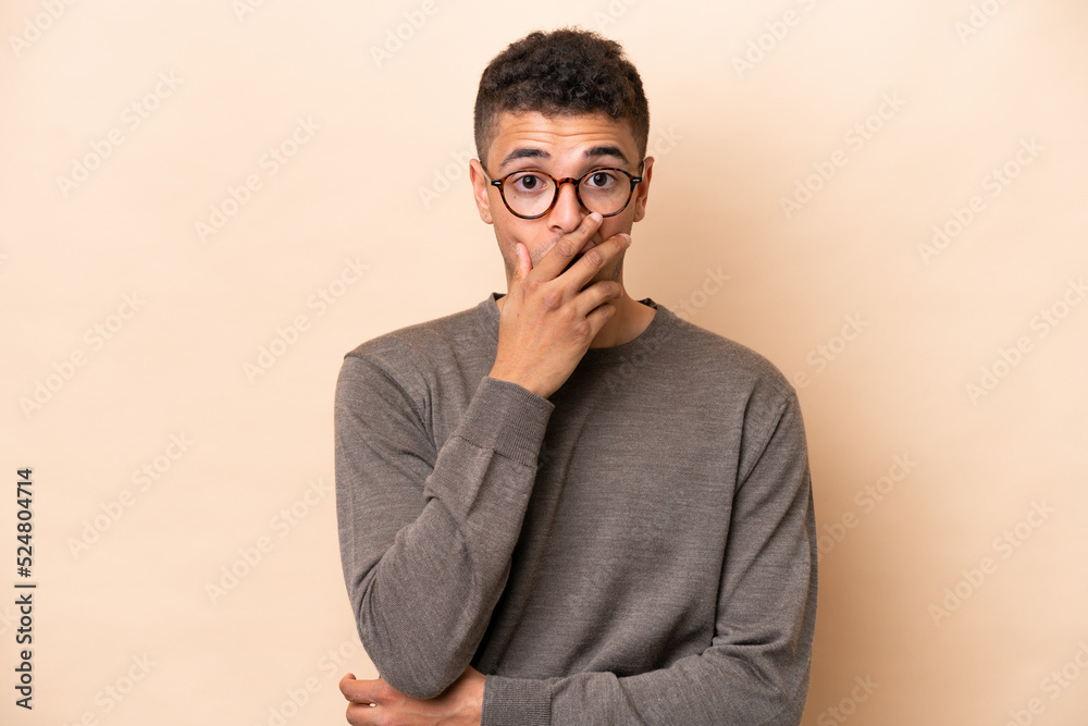 Young Brazilian man isolated on beige background surprised and shocked while looking right Young Brazilian man isolated on beige background surprised and shocked while looking right