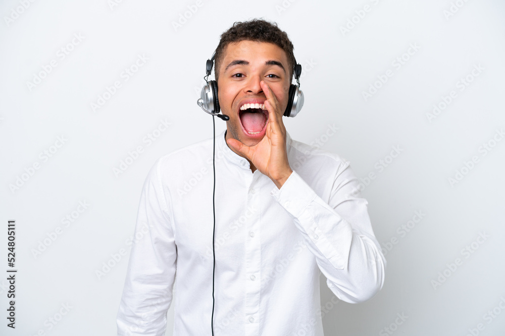 Telemarketer Brazilian man working with a headset isolated on white background shouting with mouth wide open Telemarketer Brazilian man working with a headset isolated on white background shouting with mouth wide open