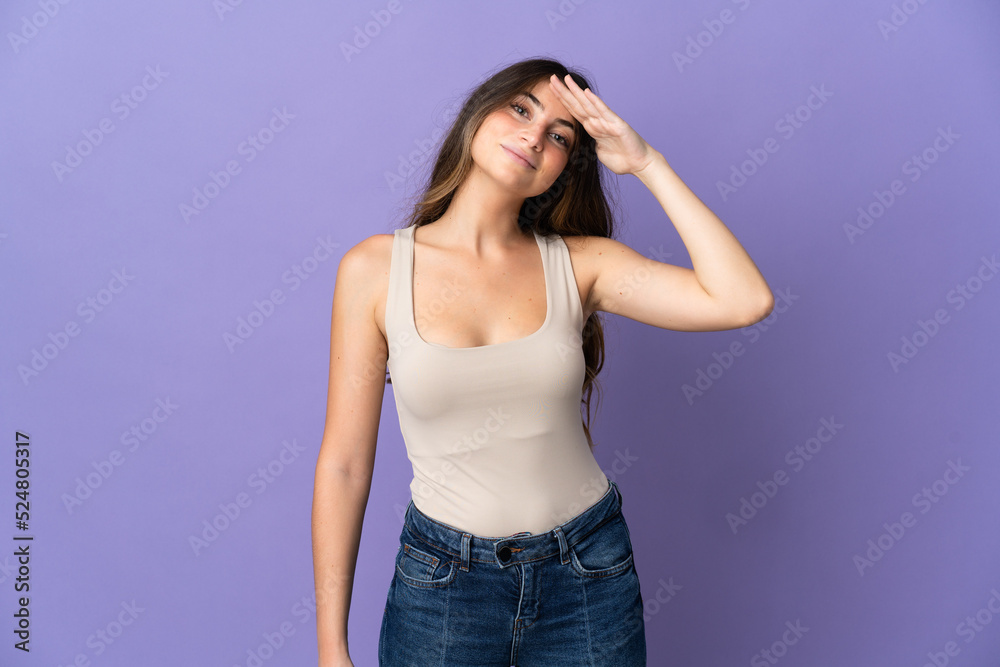 Young caucasian woman isolated on purple background saluting with hand with happy expression Young caucasian woman isolated on purple background saluting with hand with happy expression
