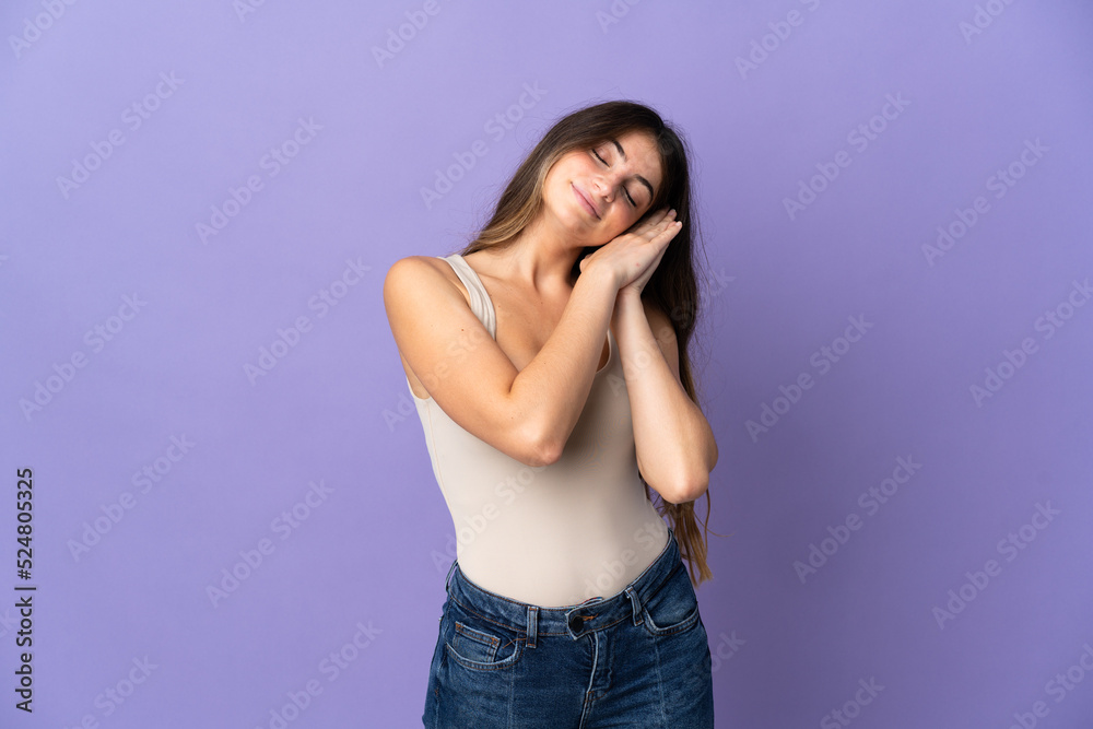 Young caucasian woman isolated on purple background making sleep gesture in dorable expression Young caucasian woman isolated on purple background making sleep gesture in dorable expression