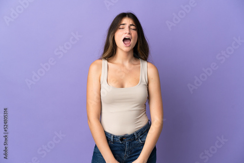 Young caucasian woman isolated on purple background shouting to the front with mouth wide open
