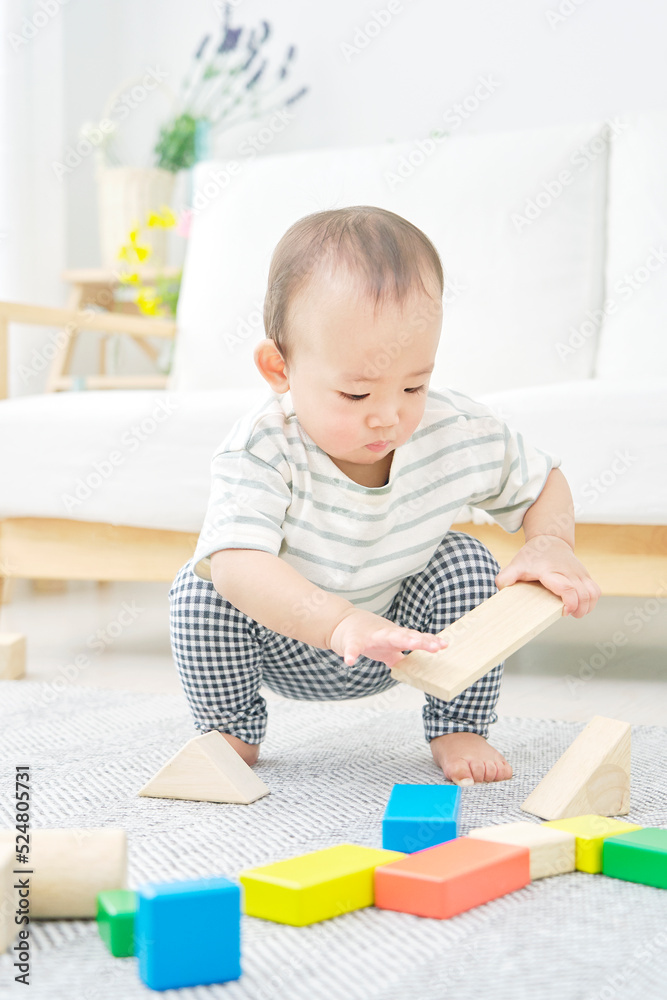 リビングで一人で積み木で遊ぶ赤ちゃん リビングで一人で積み木で遊ぶ赤ちゃん