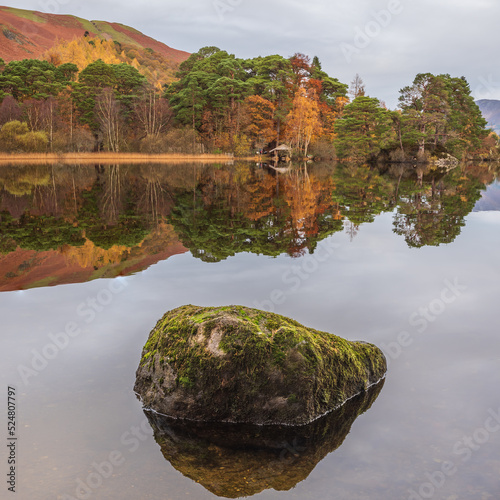 Beautiful Autumn landscape sunrise image looking towards Catbells from Manesty Park in Lake District with mist rolling across the landscape photo