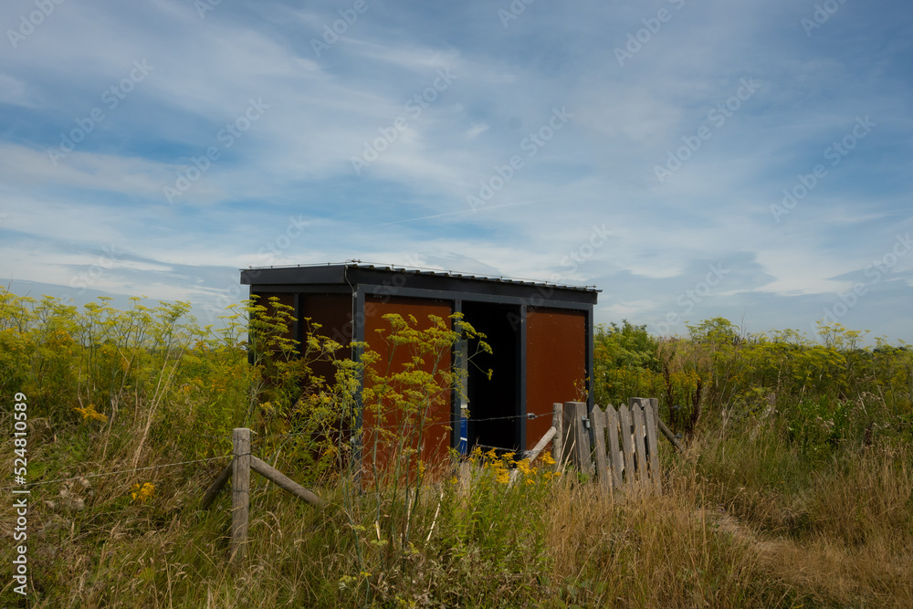 Obraz premium A birdwatching hut in the Dutch countryside near Nieuw Beijerland. These structures are available to the public in the Netherlands to view wildlife in its natural environment