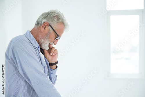Pensive elderly man is pondering about his business work at office, isolated over white background. Thoughtful man concept, emotional expression, thoughtful business man background with effect filter.