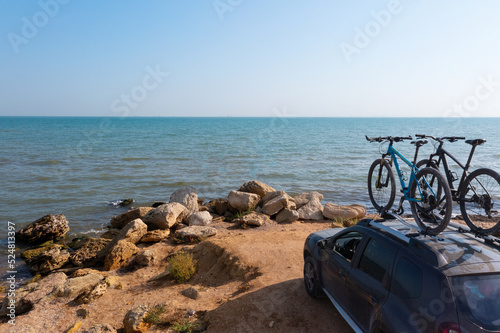 Two bikes on the roof rack of a car against a beautiful nature.
