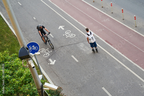 Top aerial view of cyclist and inline skater on cycling road.