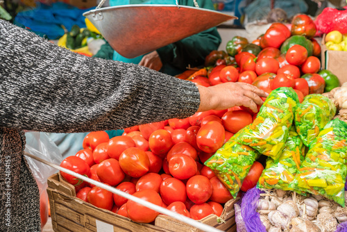 Unrecognizable buyer picking ripe tomatoes in store photo