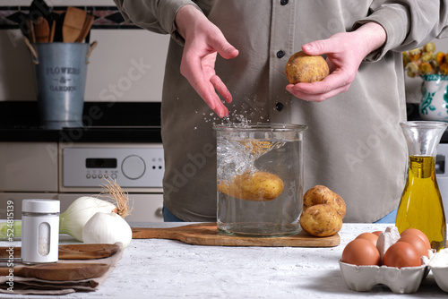 Person washing potatoes before cooking photo
