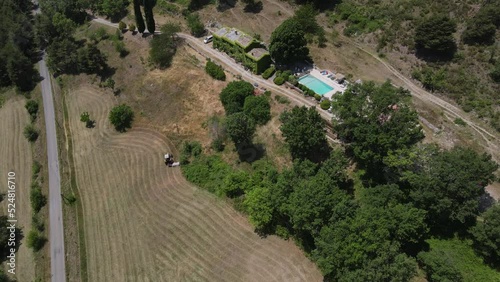 Aerial view of farmer harvest hay during heatwave in France - Canicule in the french Alps while harvesting hay photo