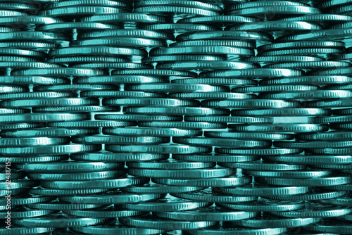 Money wall. Chaotic pile of coins close-up. Nickel coin texture. Teal tinted business background made of many coin edges. Economy finance and bank backdrop. Tax and credit. Macro