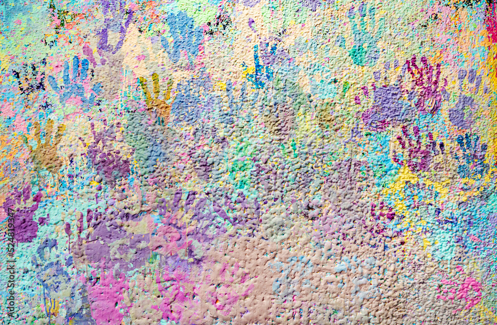 Colorful multicolored prints of children's hands on the wall