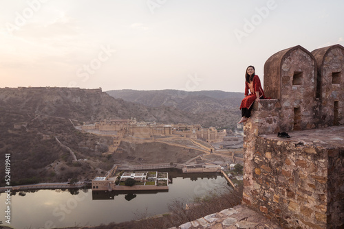 Ethnic woman sitting on old fort wall photo