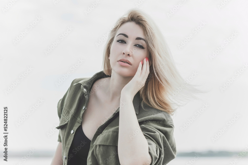 Modern blonde woman mix race in jeans jacket, fashionable details on a model, concept of trend in wardrobe Modern blonde woman mix race in jeans jacket, fashionable details on a model, concept of trend in wardrobe