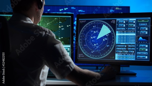 Workplace of the professional air traffic controller in the control tower. Caucasian aircraft control officer works using radar, computer navigation and digital maps. Aviation concept.
