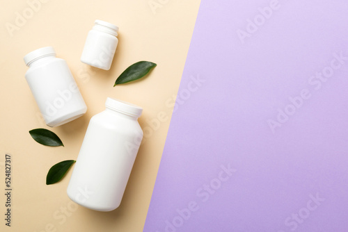 supplement pills with medicine bottle health care and medical top view. Vitamin tablets. Top view mockup bottle for pills and vitamins with green leaves, natural organic bio supplement, copy space © sosiukin