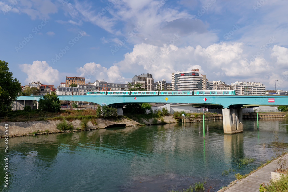 Fototapeta premium Aerial subway over the Marne river in Charenton-Le-pont city. Grand Paris area