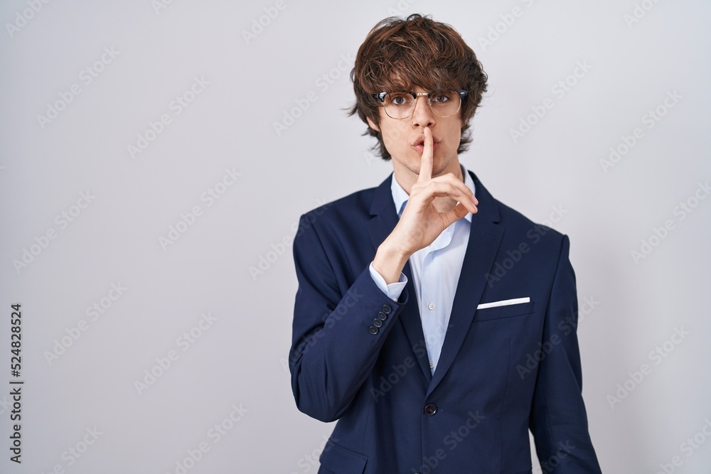 Hispanic business young man wearing glasses asking to be quiet with finger on lips. silence and secret concept. Hispanic business young man wearing glasses asking to be quiet with finger on lips. silence and secret concept.