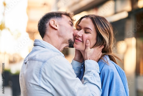 Young man and woman couple hugging each other and kissing standing at street © Krakenimages.com