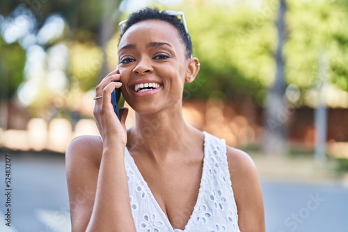 African american woman smiling confident talking on the smartphone at street